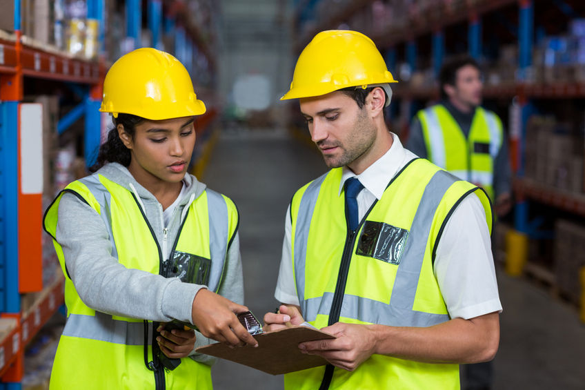 man and woman working together wearing construction west and helmet