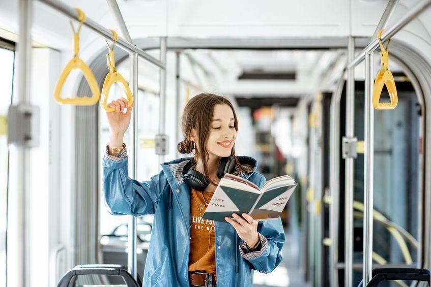 young woman reading on public transportation