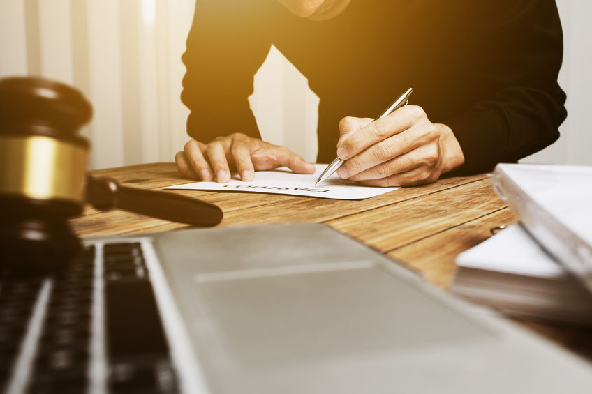 man signing paper at court house