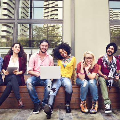 diverse group of young adults sitting together outside