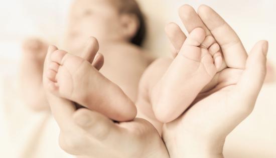 hands holding up baby feet